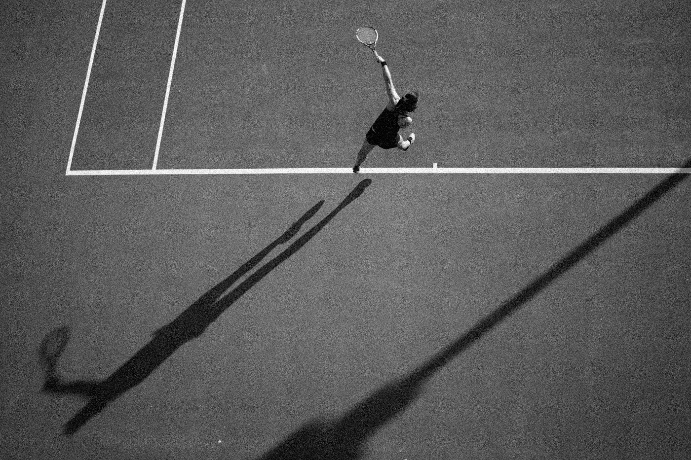 Joueur de tennis au service sur terre battue, vue de dessus