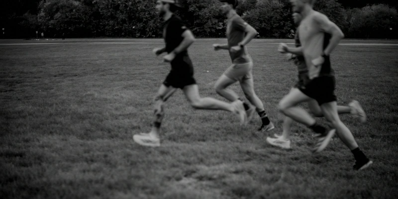 Joueurs en pleine course sur terrain d'entraînement, mouvement flou